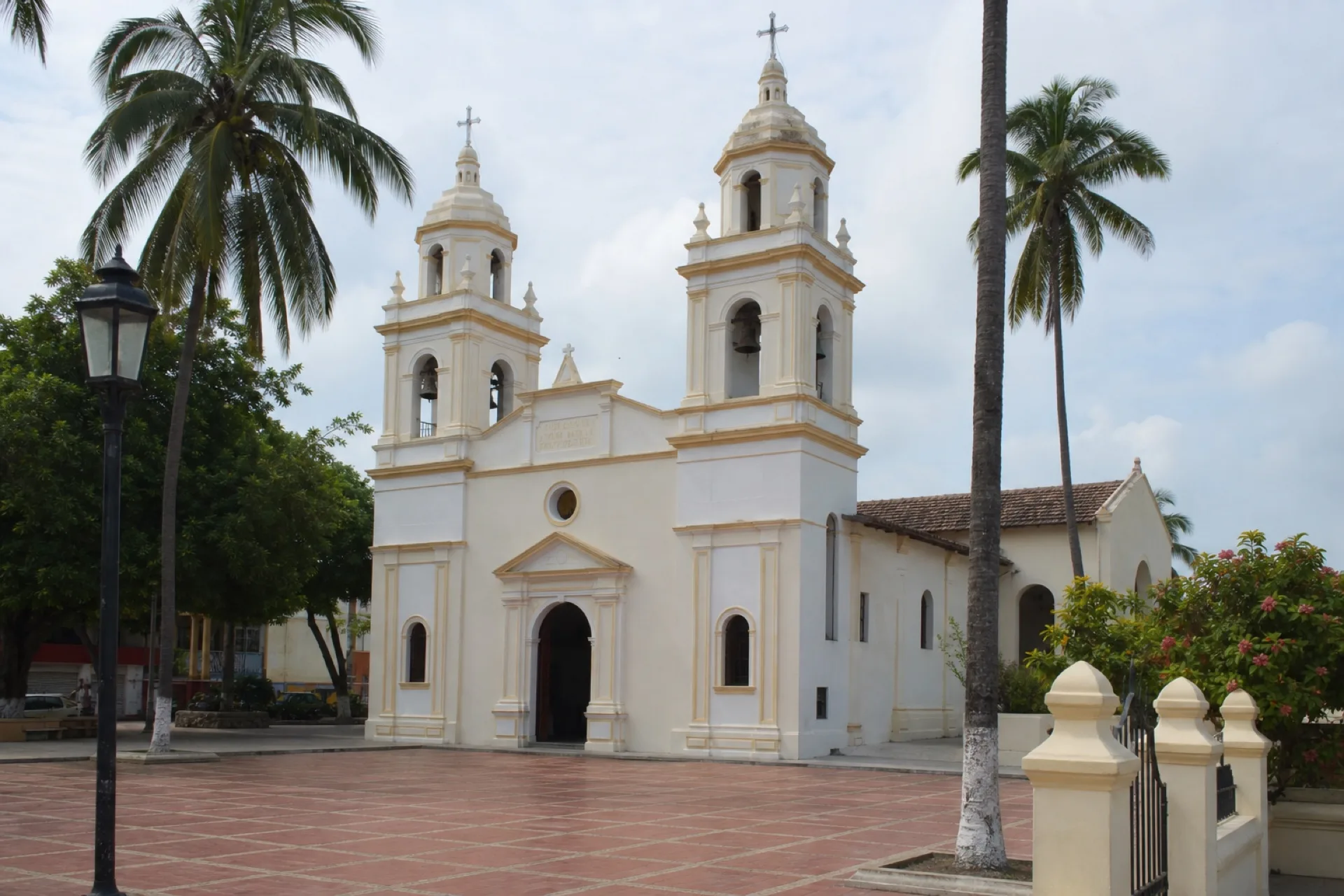 Parroquia de San Pedro Apóstol en Minatitlán, torres crema y atrio.