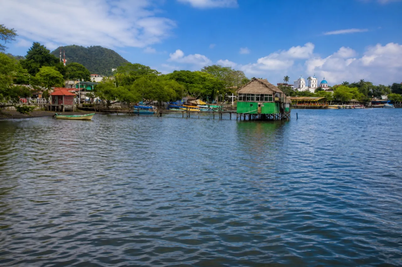 Malecón de Catemaco con muelles, lanchas y palapa sobre el lago.