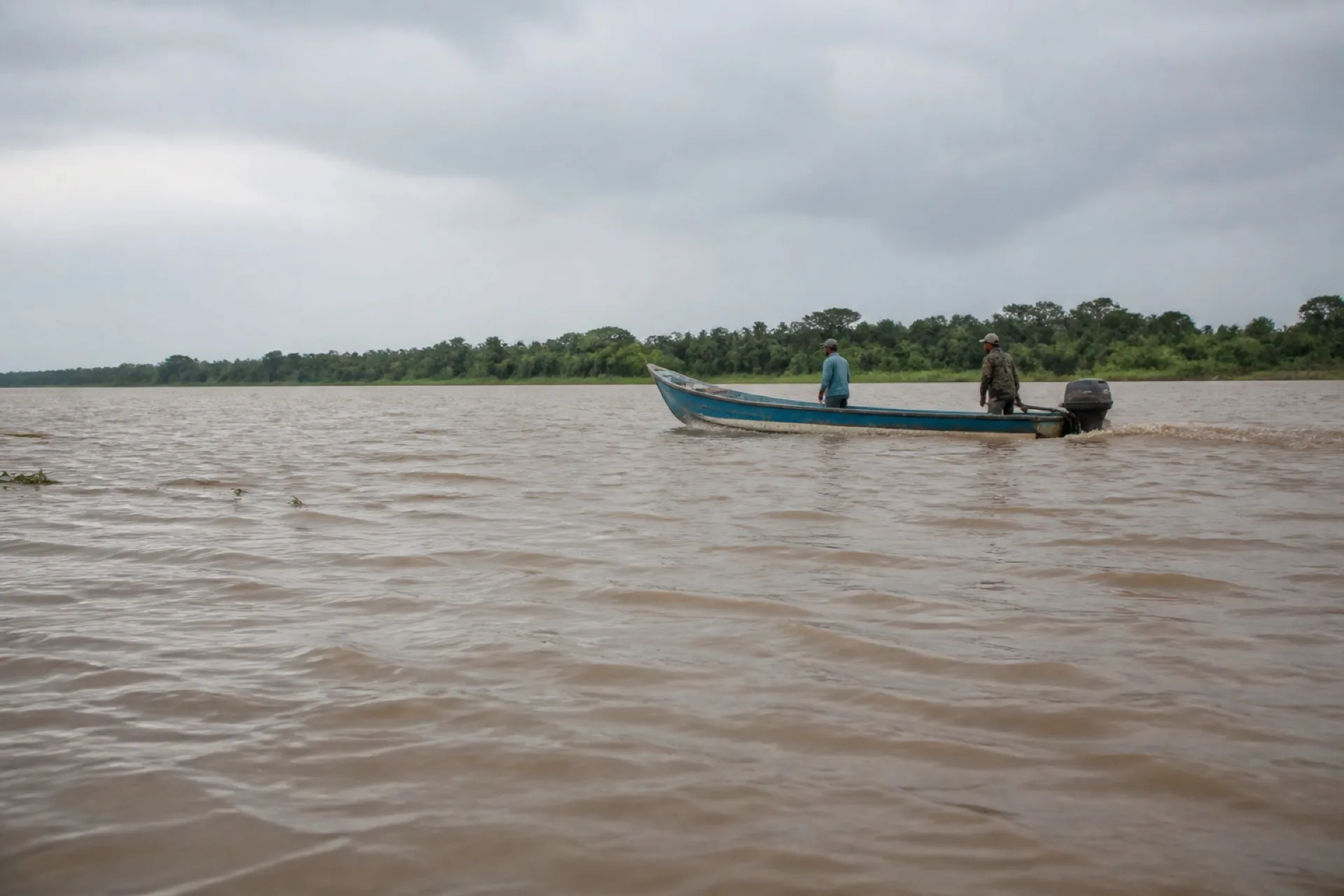 Panga en el río Pánuco, con orillas bajas y agua turbia.
