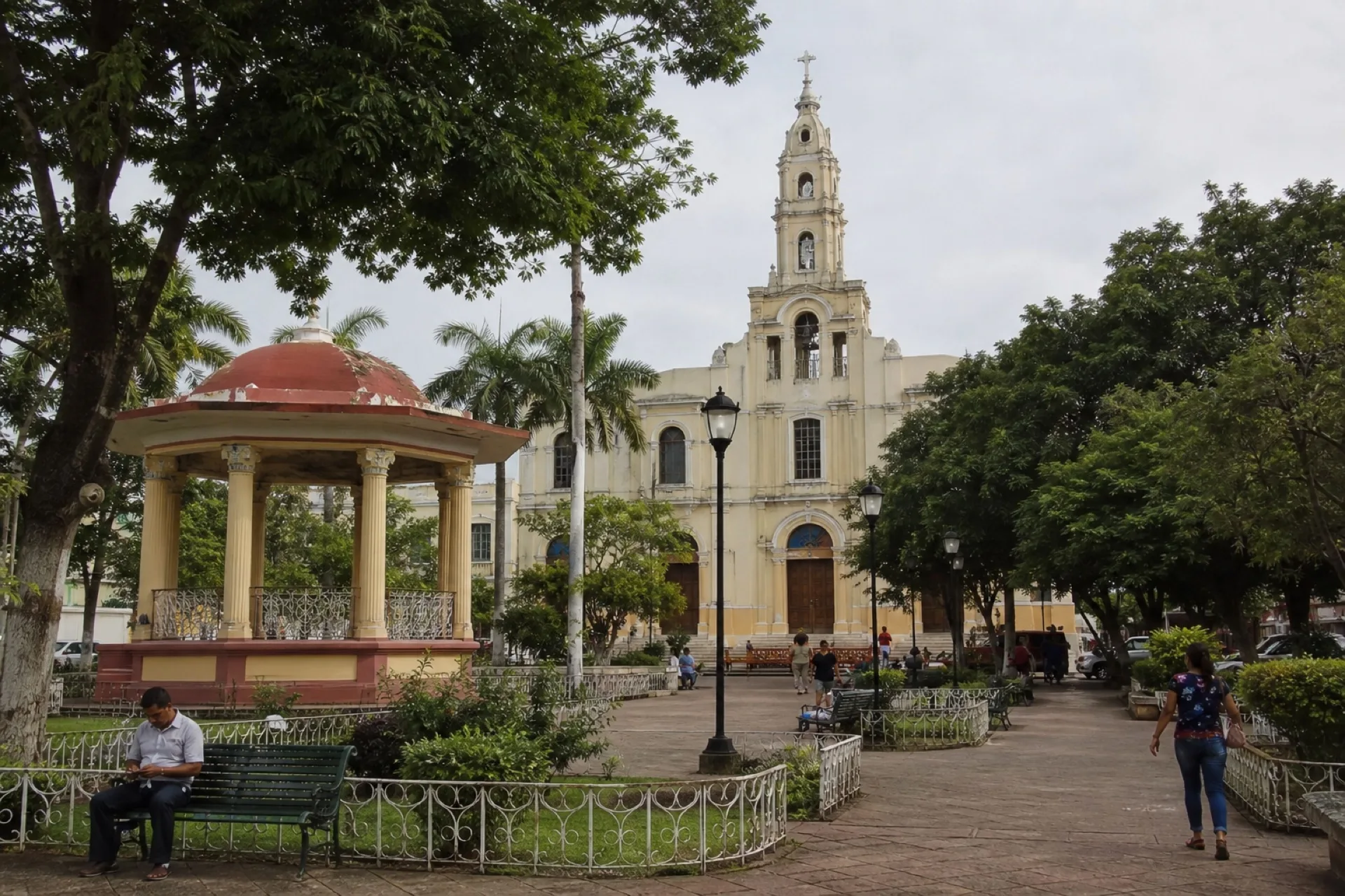 Plaza arbolada de Acayucan con kiosco y parroquia al fondo.