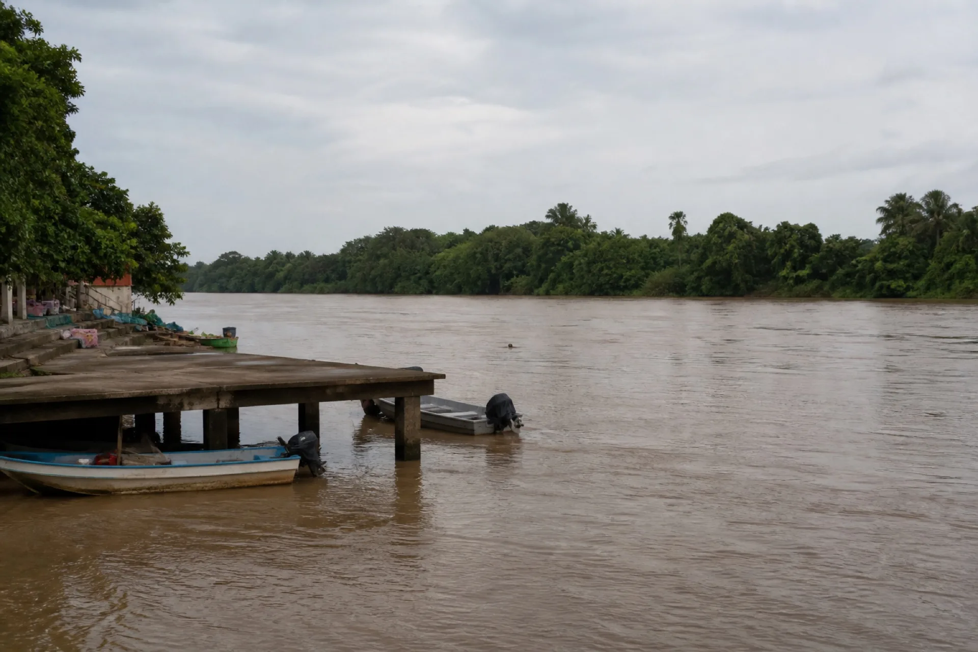 Ribera interior del Coatzacoalcos con muelle sencillo y lanchas, no mar abierto.