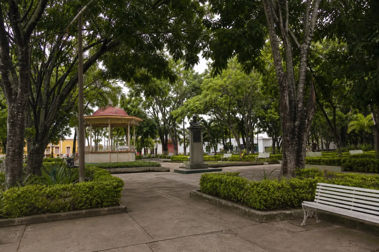 Parque urbano con kiosco, árboles y un busto en el centro de un puerto veracruzano.