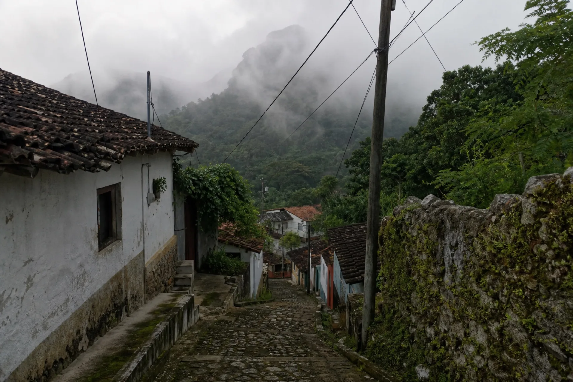 Calle de Colatlán con techos de teja y lomerío al fondo.