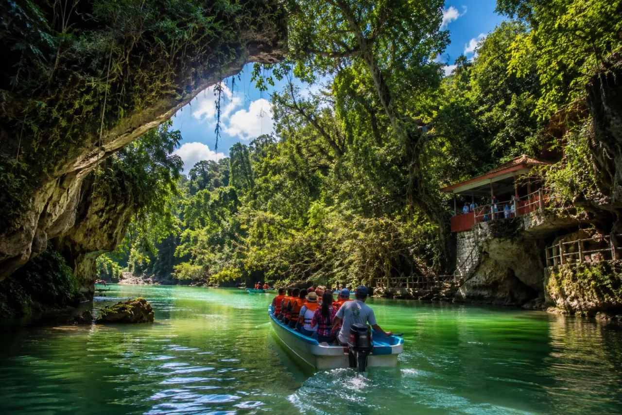 Lancha con viajeros navegando un cauce selvático de Catemaco.